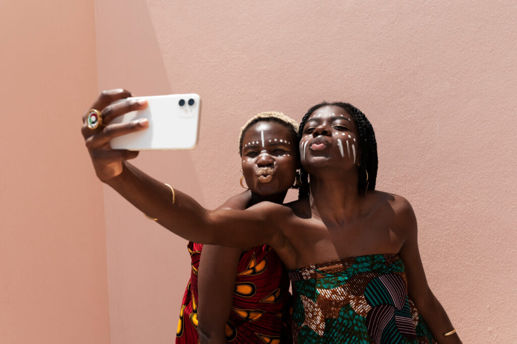 Portrait of women outdoors in african attire and fashion depicting people jumping on social media trends 